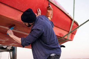 A man was asked to paint a boat.